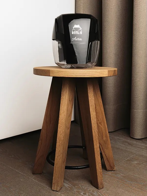 HYLA AERA II Black auf einem Holzhocker im Wohnraum